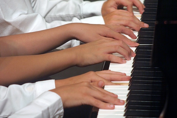 Children's hands playing the piano