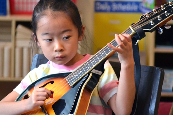 Young girl playing mandolin.