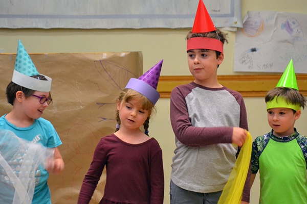 Young children wearing colorful hats.