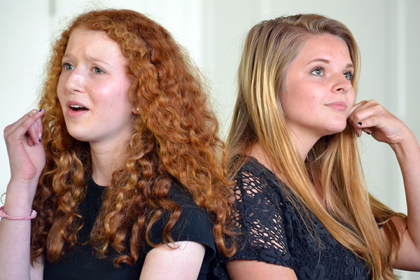 Musical theater scene of two teen girls speaking on imaginary phones.