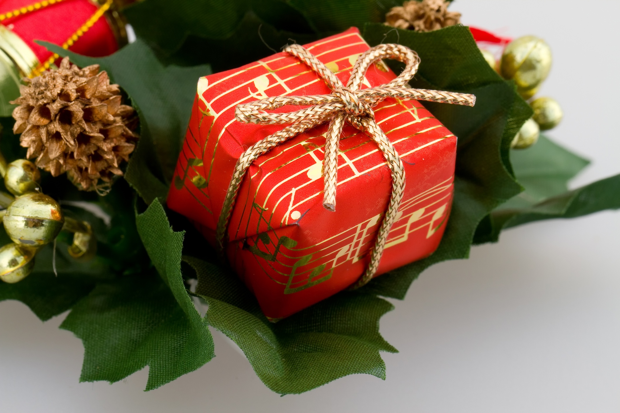 Christmas gift wraped with red paper printed with gold design musical symbols