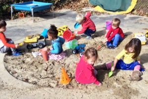 Preschoolers playing in sandbox.