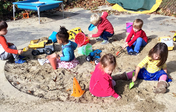 Preschoolers playing in sandbox.