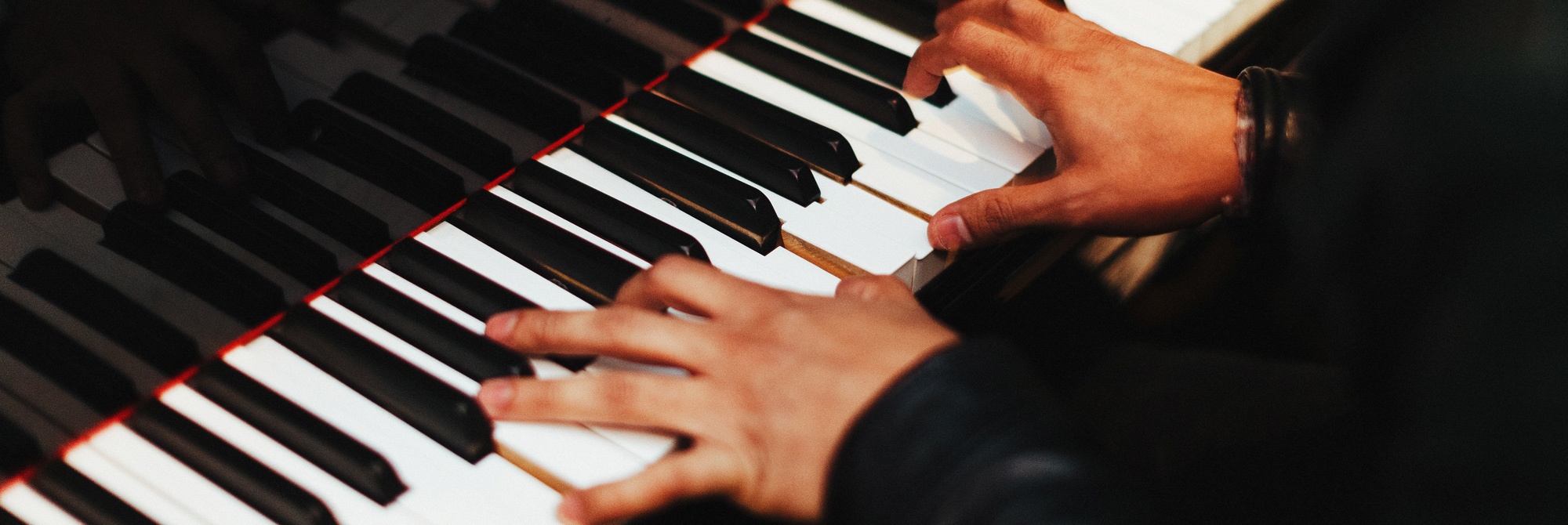 Hands playing a piano