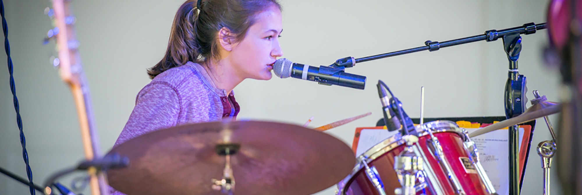 Teen girl playing drums and singing