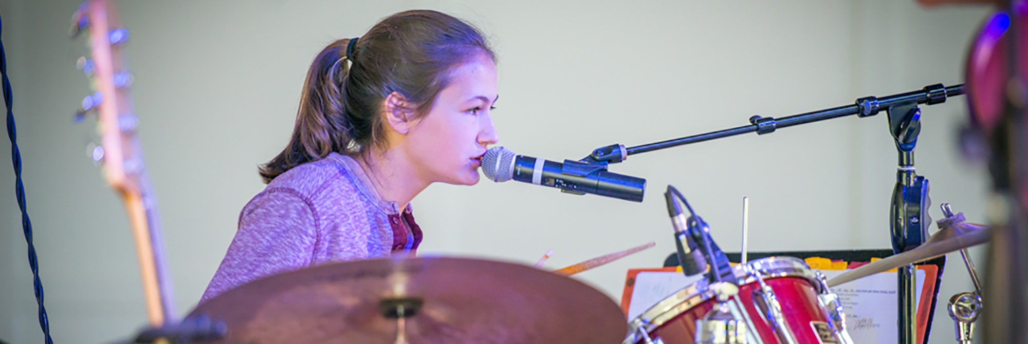 Teen girl playing drums and singing