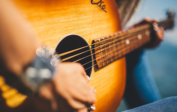 Musician playing an acoustic guitar.