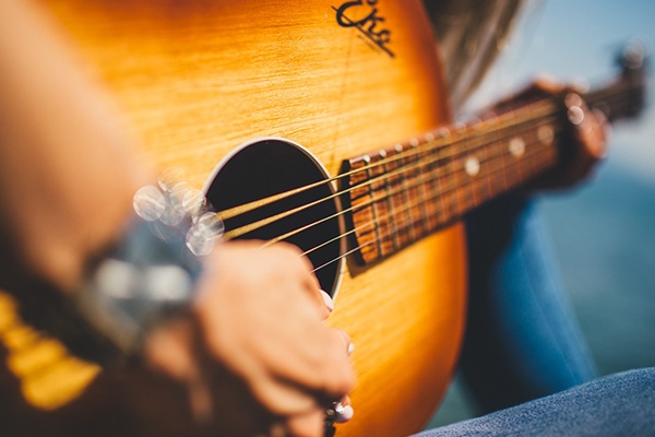 Musician playing an acoustic guitar.