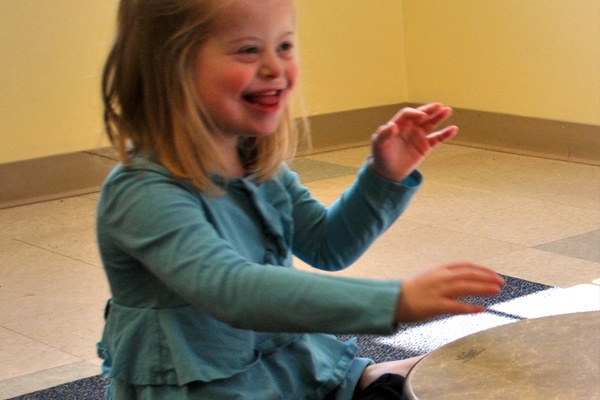 child playing a hand drum.