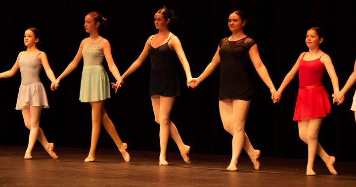 row of teen ballet students dancing