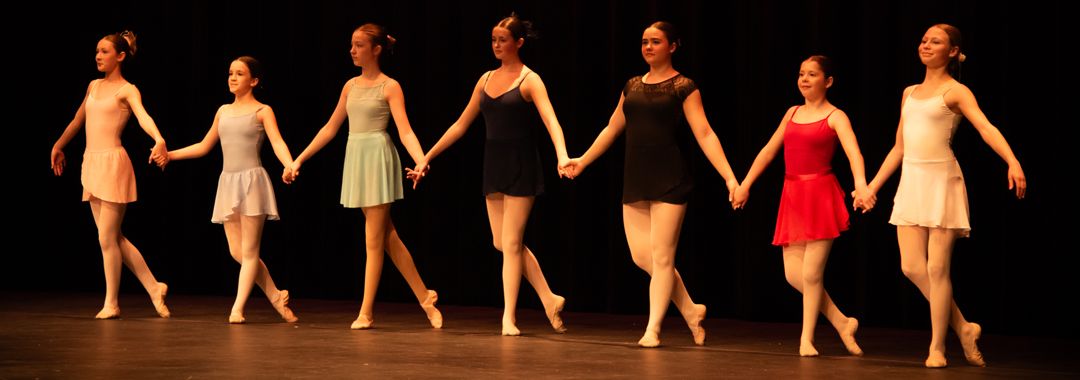 row of teen ballet students dancing