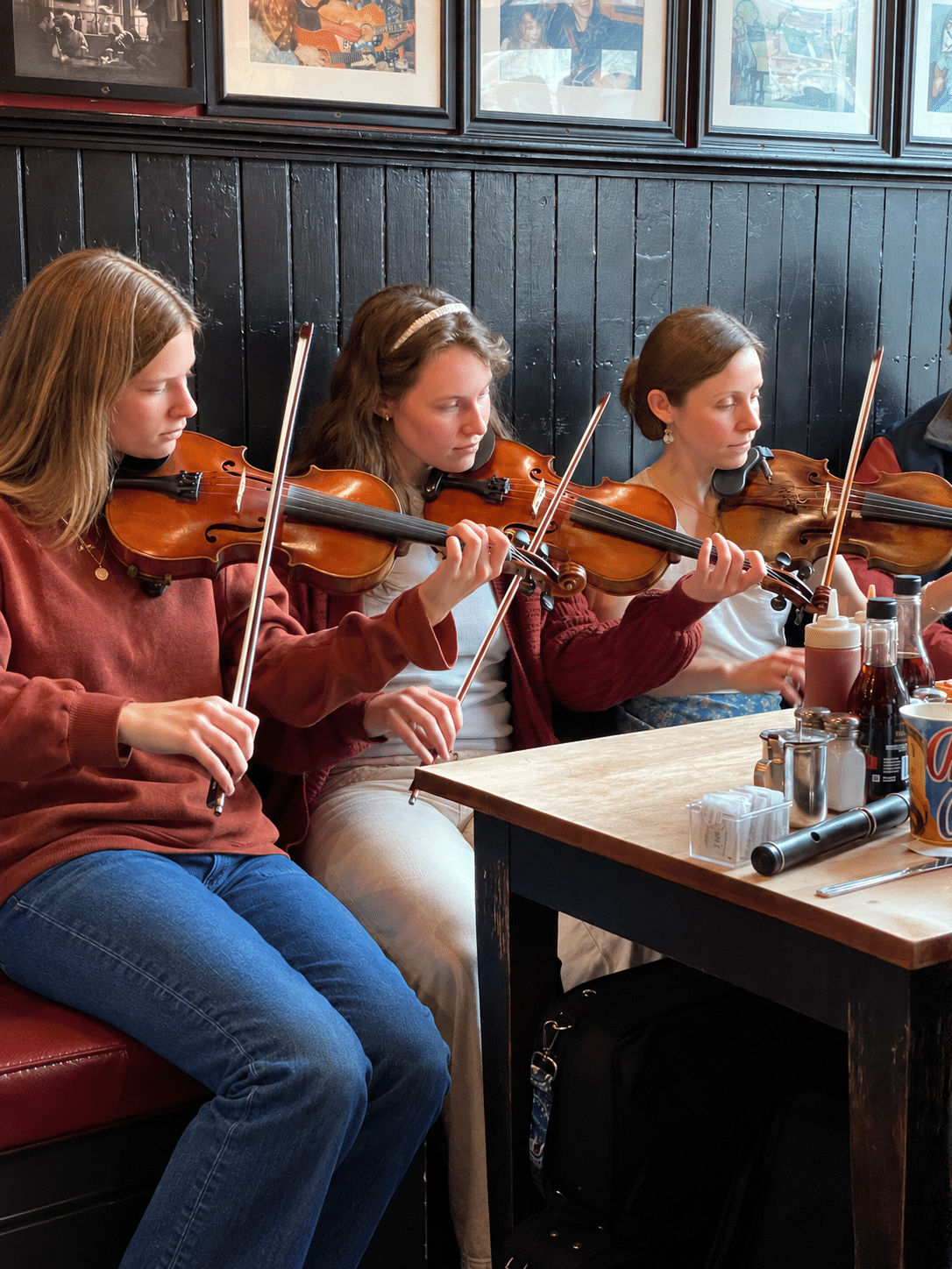 Irish traditional fiddle musicians playing together at a session in the Boston area